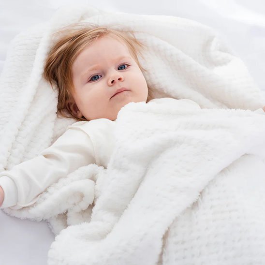 couverture bebe gaufre blanc allonge regarde