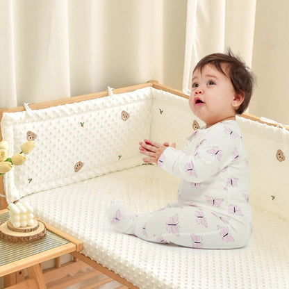 tour de lit bebe assis dans berceau bois