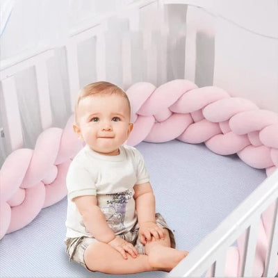 tresse de lit rose bebe assis dans berceau